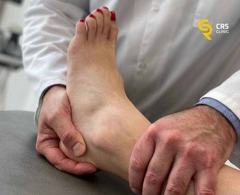 Lekarz ortopeda wykonuje badanie kliniczne tendinopatii ścięgna achillesa