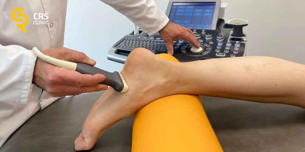 Lekarz ortopeda wykonuje badanie ultrasonograficzne w kierunku tendinopatii ścięgna Achillesa