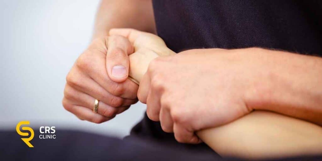 Fizjoterapeuta sprawdza u pacjentki typowe objawy zespołu cieśni nadgarstka w CRS Clinic Warszawa