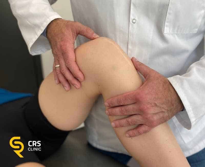 Lekarz ortopeda wykonuje badanie diagnostyczne bólu kolana przed zabiegiem sonochirurgicznym w CRS Clinic Warszawa