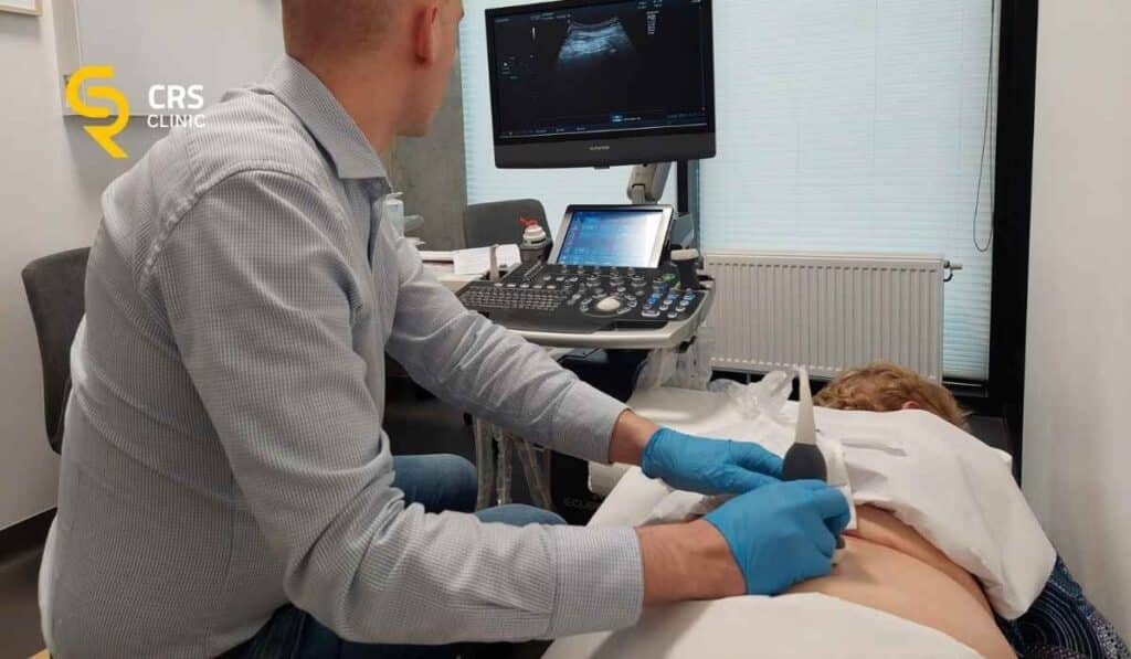 Lekarz neurochirurg przeprowadza diagnostykę USG bólu pleców przy rwie kulszowej w CRS Clinic Warszawa