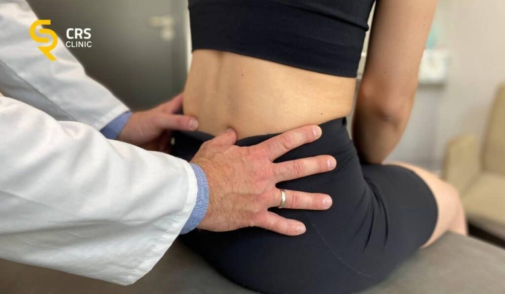 Lekarz ortopeda przeprowadza dokładne badanie kliniczne bólu kręgosłupa w CRS Clinic Warszawa