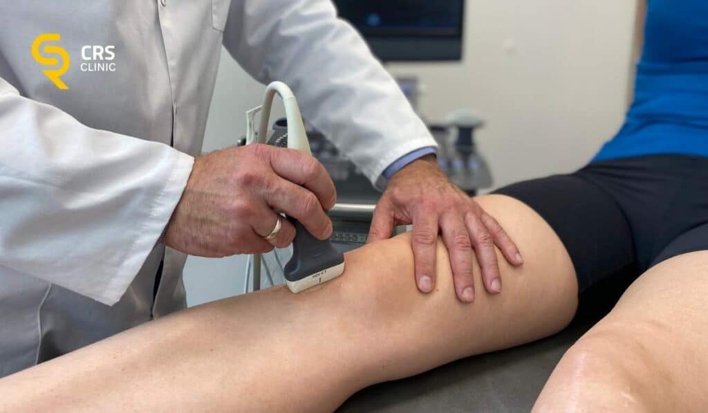 Lekarz ortopeda przeprowadza diagnostykę USG u pacjentki z bólem kolana w CRS Clinic Warszawa