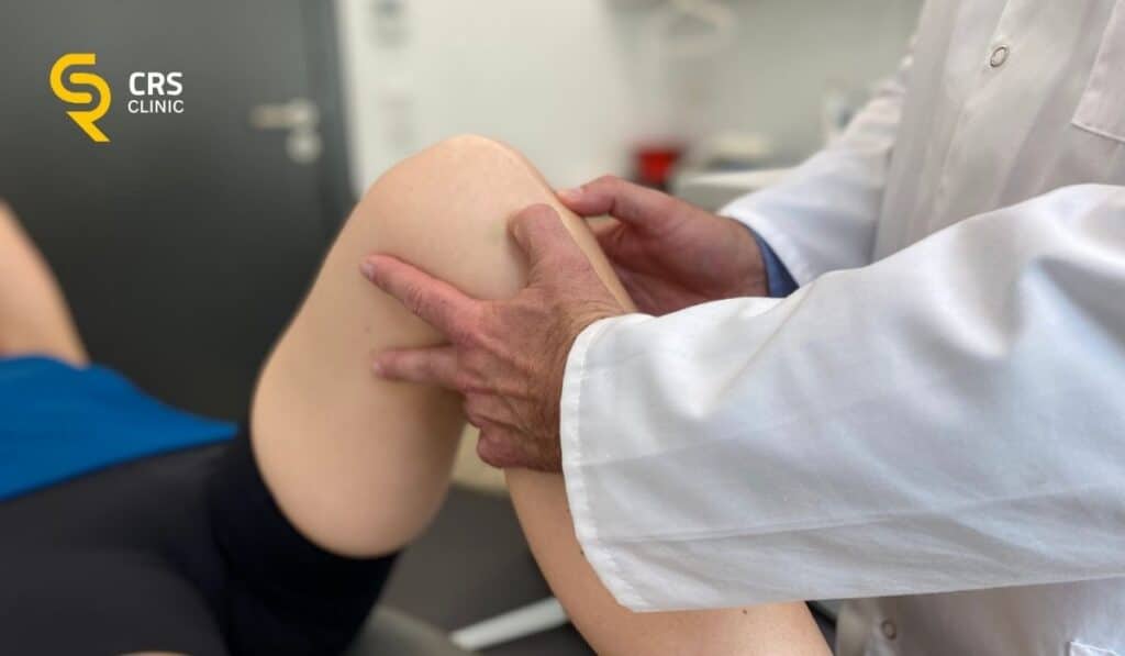 Lekarz ortopeda wykonuje badanie kliniczne stawu kolanowego u pacjentki w CRS Clinic Warszawa