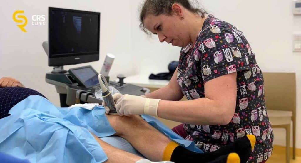 Lekarz ortopeda wykonuje iniekcję kwasu hialuronowego do kolana pod kontrolą USG w CRS Clinic Warszawa