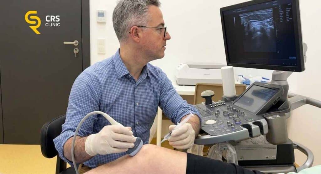Lekarz ortopeda wykonuje zastrzyk kwasu hialuronowego do kolana pod USG w CRS Clinic Warszawa
