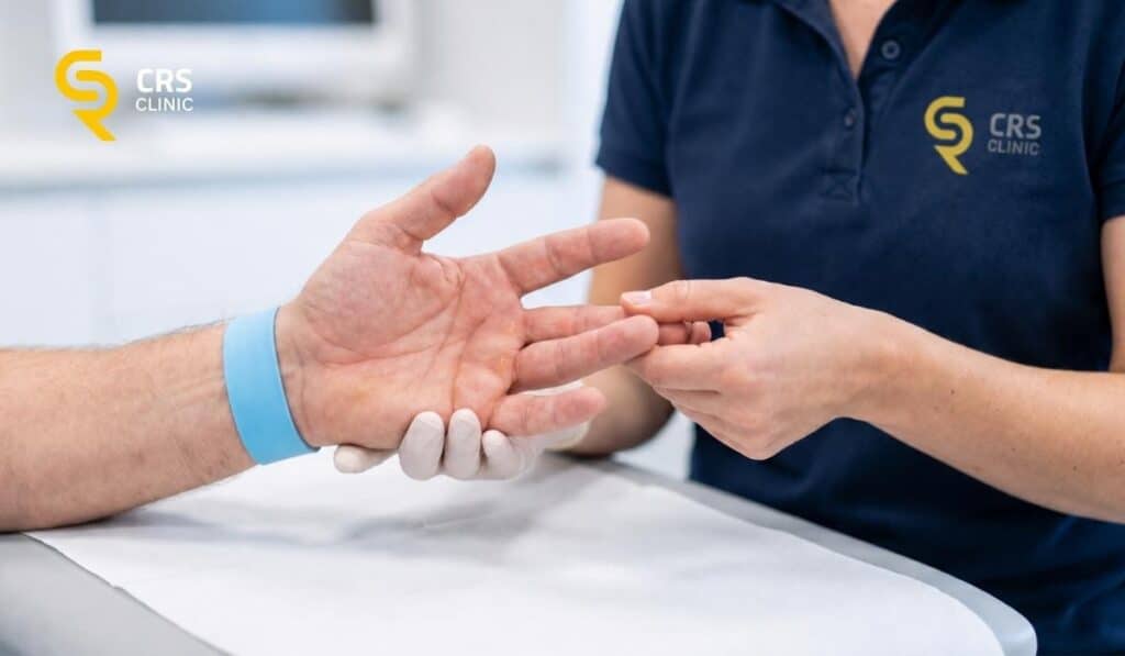 Lekarz ortopeda przeprowadza badanie kliniczne u pacjenta z bólem palców w CRS Clinic Warszawa