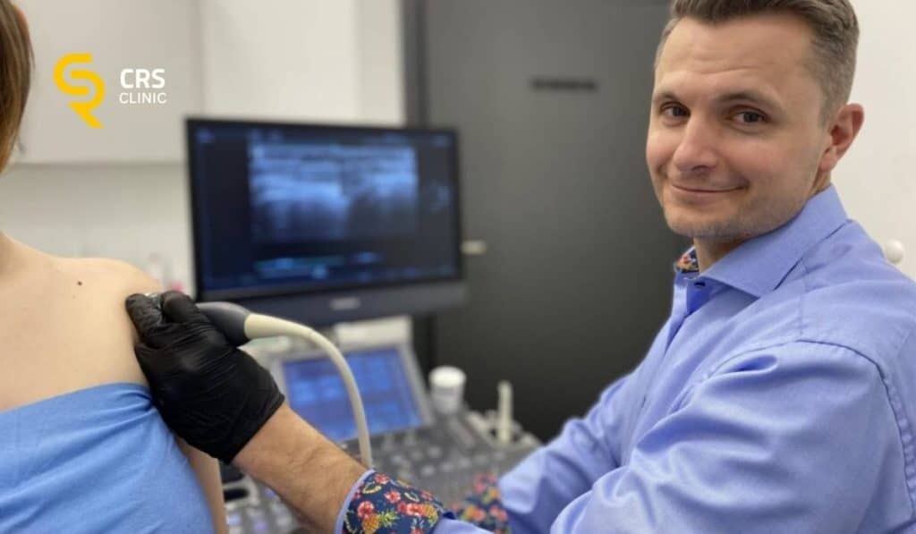 Lekarz ortopeda wykonuje badanie USG u pacjentki z potwierdzonym zwapnieniem w barku w CRS Clinic Warszawa