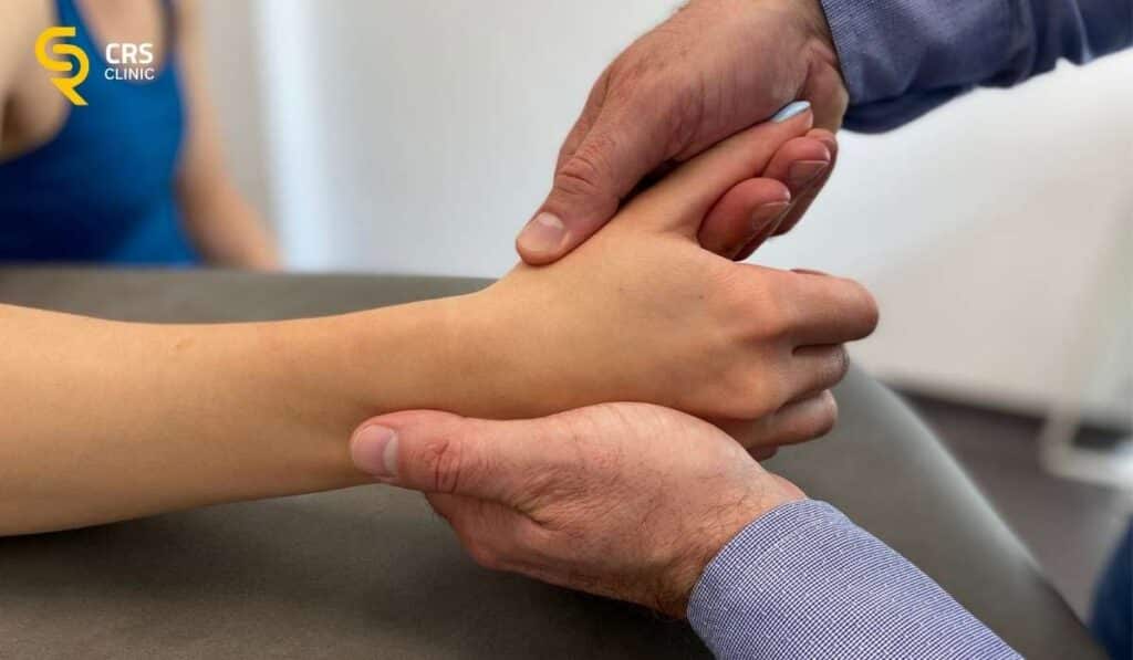 Lekarz ortopeda wykonuje badanie kliniczne u pacjentki ze strzelającym kciukiem w CRS Clinic Warszawa