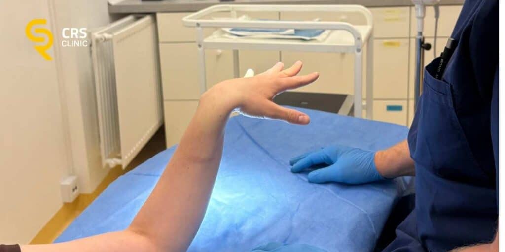 Lekarz ortopeda przygotowuje pacjentkę do zabiegu operacyjnego na palec zatrzaskujący w CRS Clinic Warszawa