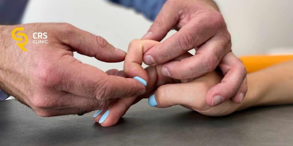 Lekarz ortopeda wykonuje badanie kliniczne palca zatrzaskującego w CRS Clinic Warszawa
