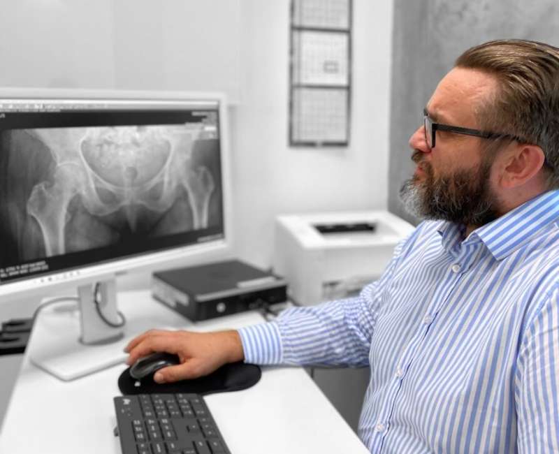 Lekarz sprawdza wyniki rezonansu w kierunku rozpoznania zapalenia biodra