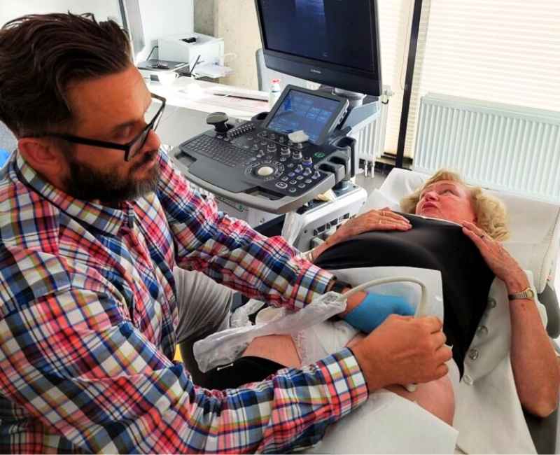 Lekarz wykonuje badanie USG przed podaniem blokady biodra