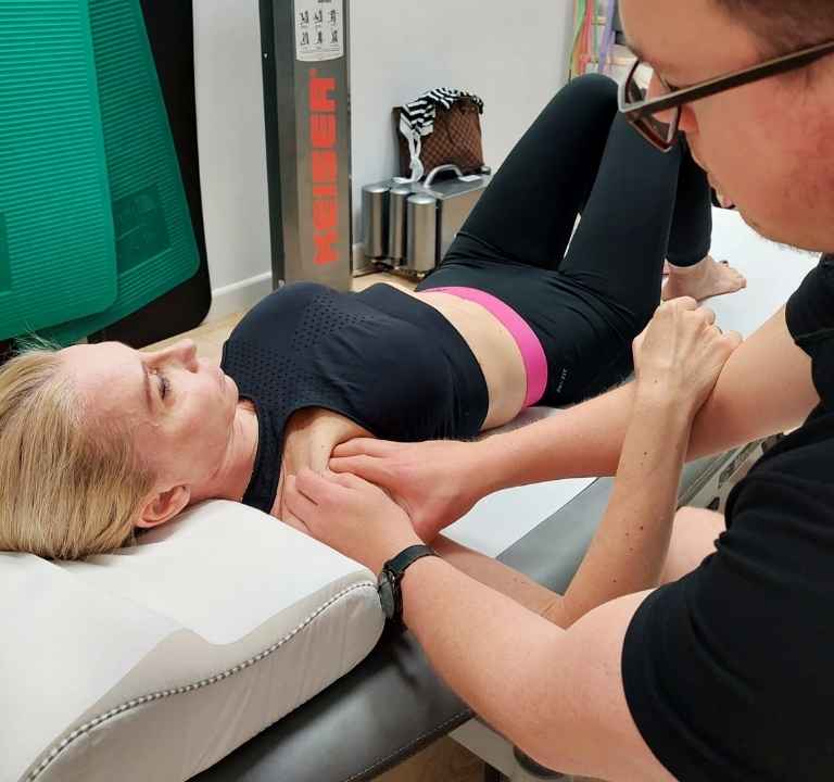 Fizjoterapeuta CRS Clinic ćwiczy bark z pacjentką po zabiegu barbotage