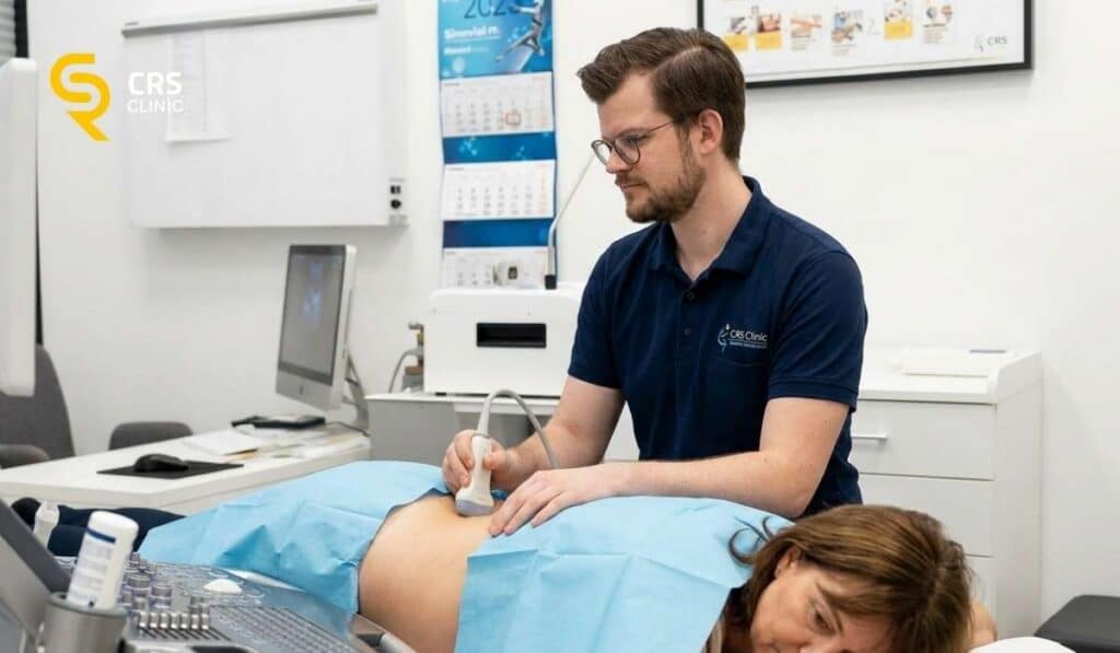 Lekarz neurochirurg wykonuje badanie USG u pacjentki ze zwyrodnieniem kręgosłupa przez blokadą diagnostyczną w CRS Clinic Warszawa