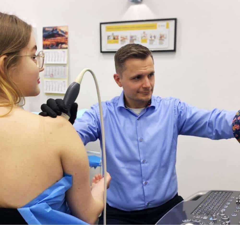 Lekarz ortopeda wykonuje badanie USG zwapnień barku