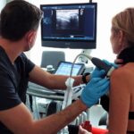 Lekarz ortopeda wykonuje małoinwazyjny zabieg barbotażu