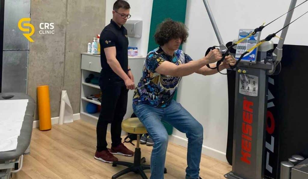 Fizjoterapeuta pracuje z pacjentem i wykonuje ćwiczenia na wzmocnienie pleców przy dyskopatii lędźwiowej w CRS Clinic Warszawa