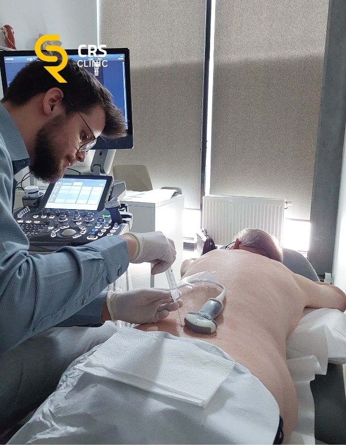 Lekarz neurochirurg wykonuje blokadę kręgosłupa pod kontrolą USG w CRS Clinic Warszawa