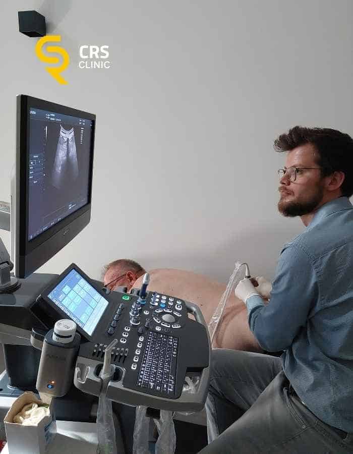 Lekarz neurochirurg wykonuje diagnostykę USG bólu kręgosłupa u pacjenta w CRS Clinic Warszawa