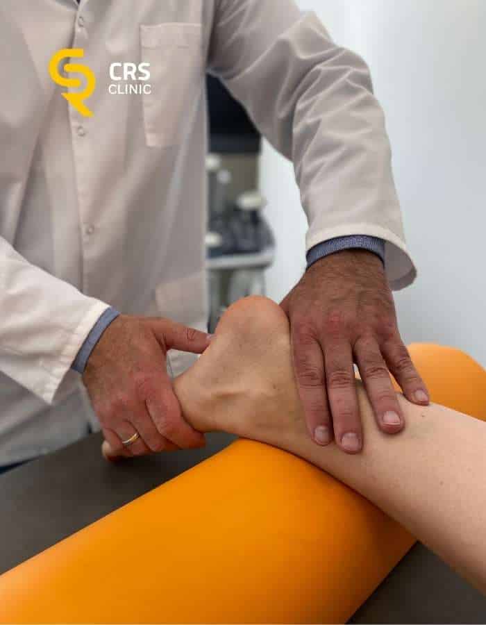Lekarz ortopeda przeprowadza badanie kliniczne w kierunku ostrogi piętowej w CRS Clinic Warszawa