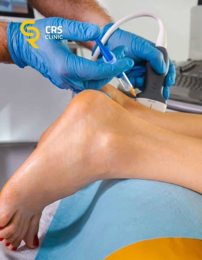 Lekarz ortopeda wykonuje iniekcję przeciwzapalną w stawie skokowym u pacjenta w CRS Clinic Warszawa