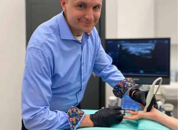 Doktor Mateusz Przybycień wykonuje zabieg na palec strzelający