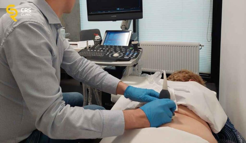 Lekarz neurochirurg wykonuje zastrzyk blokady kręgosłupa lędźwiowego pod kontrolą USG w CRS Clinic Warszawa