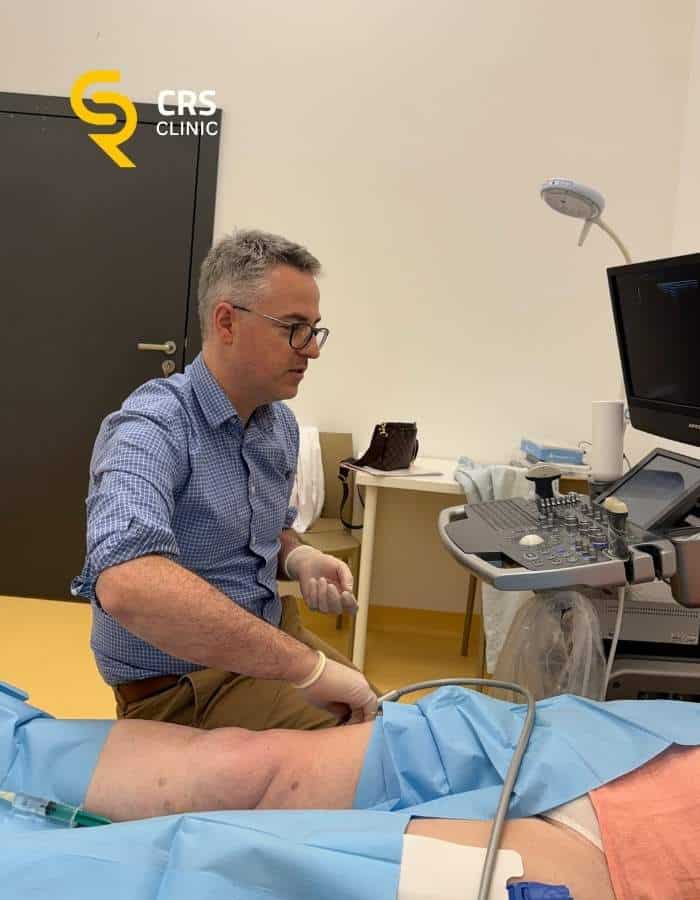 Lekarz ortopeda przygotowuje pacjentkę do badania USG zapalenia kaletki krętarza w CRS Clinic Warszawa
