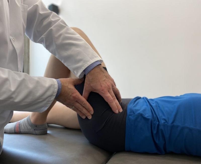 Lekarz bada u pacjentki b&oacute;l biodra