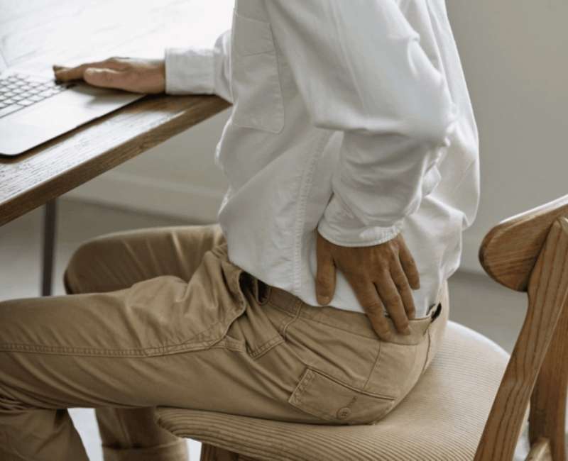 Mężczyzna odczuwa ból kręgosłupa promieniujący do nóg