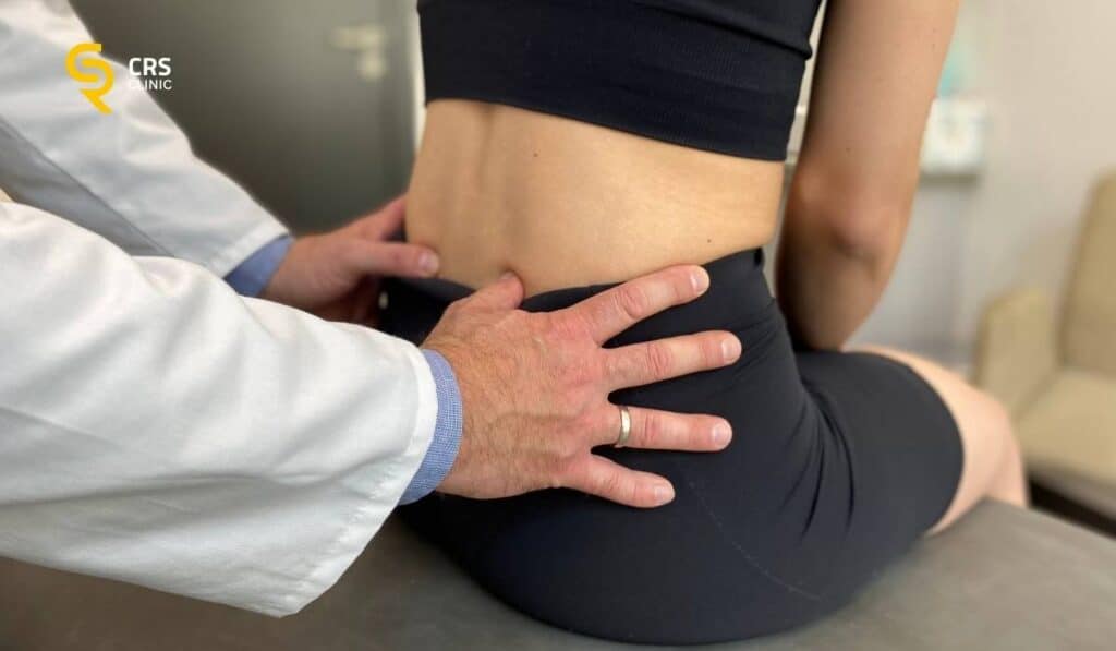 Lekarz neurochirurg wykonuje badanie kliniczne lędźwi u pacjentki po zabiegu kriolezji kręgosłupa w CRS Clinic Warszawa