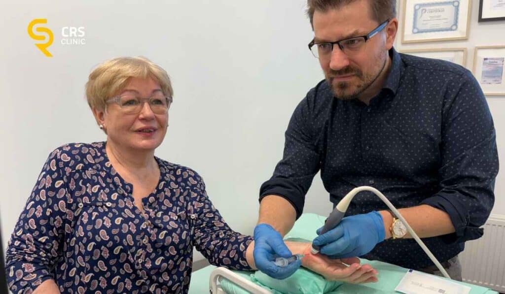Lekarz ortopeda przeprowadza iniekcję przeciwbólową u pacjentki z bólem po zewnętrznej stronie nadgarstka w CRS Clinic Warszawa