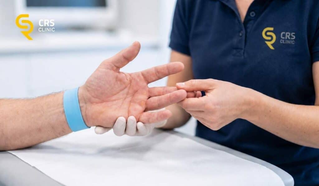 Lekarz ortopeda przeprowadza badanie kliniczne palca zatrzaskującego w CRS Clinic Warszawa