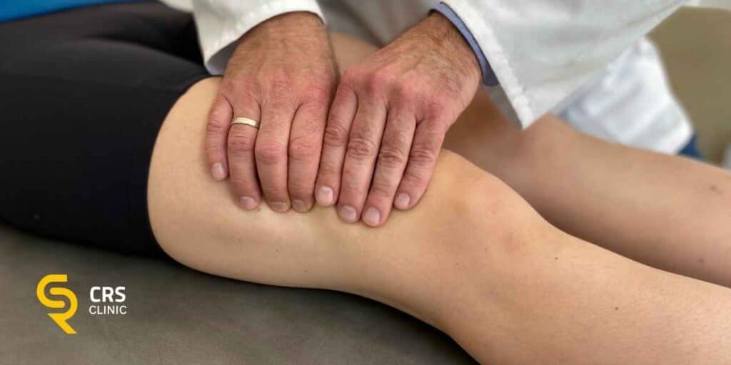 Lekarz ortopeda przeprowadza badanie kliniczne stawu kolanowego w CRS Clinic Warszawa