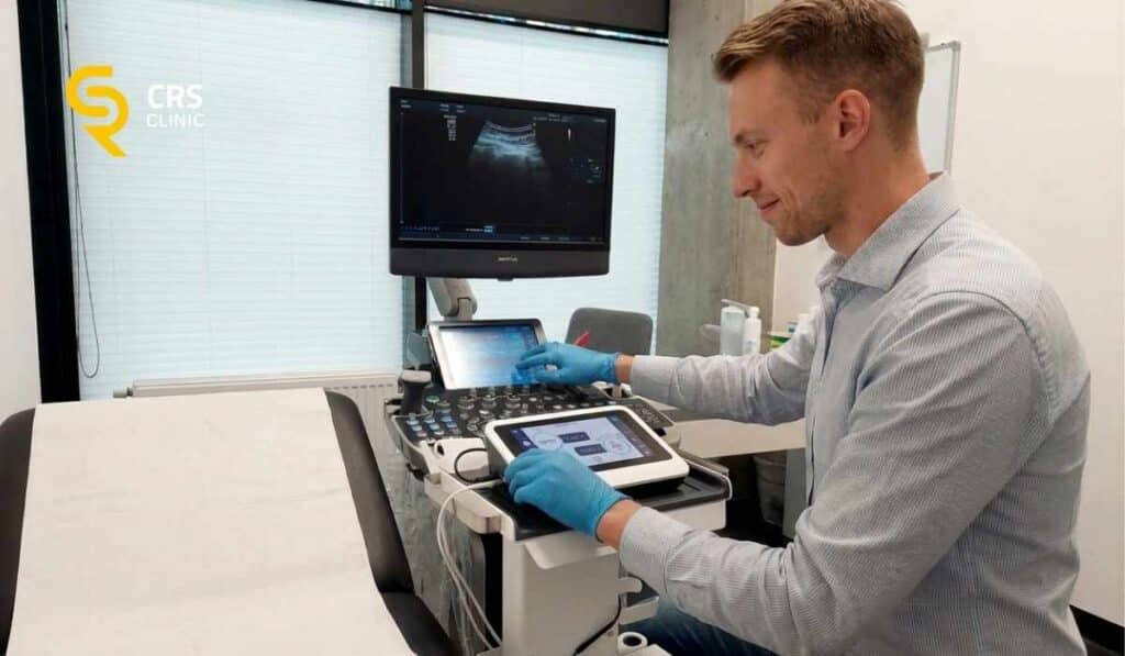 Lekarz ortopeda przygotowuje urządzenie elektrolizy do zabiegu na ścięgno Achillesa w CRS Clinic Warszawa