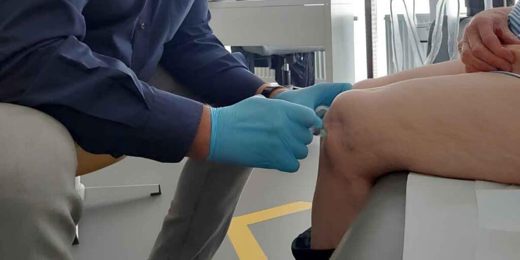 Lekarz ortopeda wykonuje zabieg podania osocza bogatopłytkowego (PRP) u pacjenta w CRS Clinic Warszawa