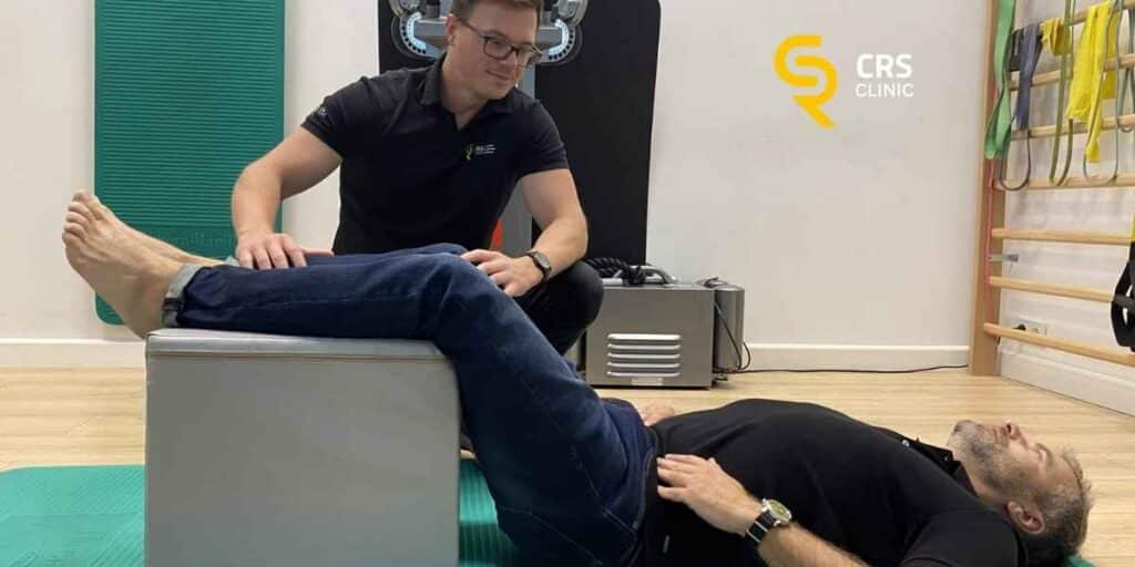 Fizjoterapeuta wykonuje z pacjentem ćwiczenia rozluźniające mięśnie kręgosłupa lędźwiowego w CRS Clinic Warszawa