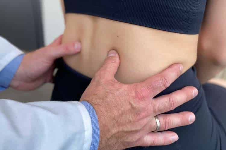 Lekarz Ortopeda przeprowadza dokładne badanie kliniczne kręgosłupa lędźwiowego pacjenta przed leczeniem w CRS Clinic Warszawa