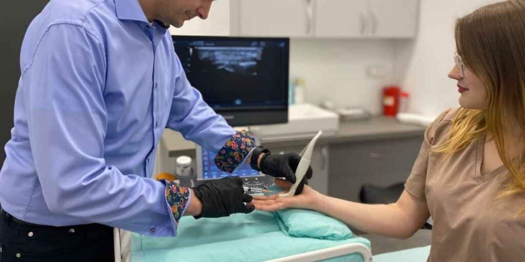 Lekarz ortopeda przeprowadza zabieg iniekcji przeciwzapalnej palca zatrzaskującego w CRS Clinic Warszawa