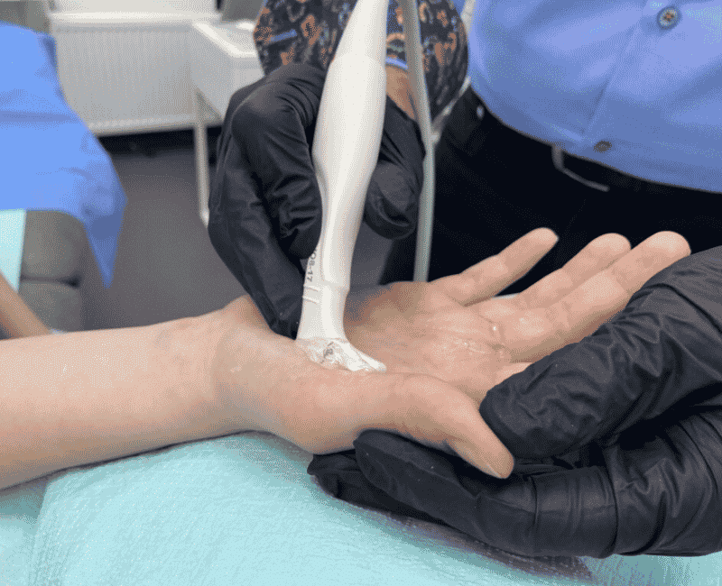 Lekarz ortopeda wykonuje badanie USG palca zatrzaskującego przed rozpoczęciem leczenia w CRS Clinic Warszawa