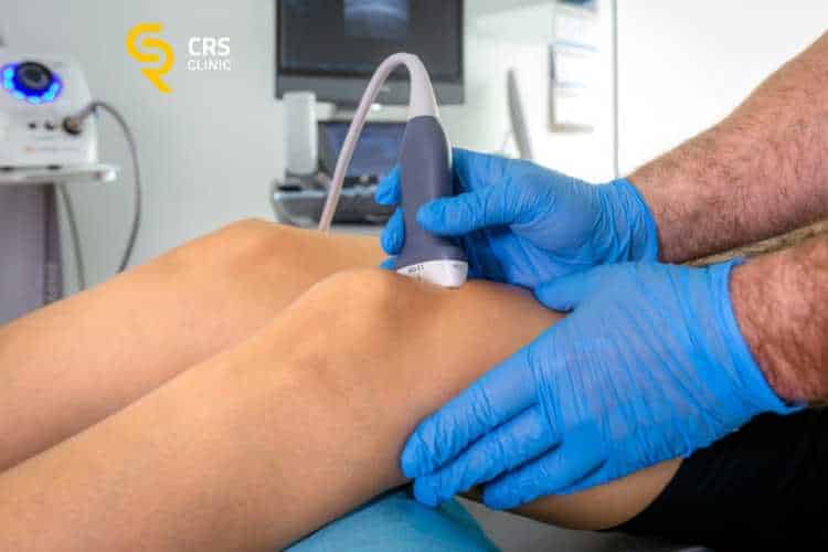Lekarz ortopeda wykonuje badanie USG zwyrodnienia kolana przed leczeniem w CRS Clinic Warszawa