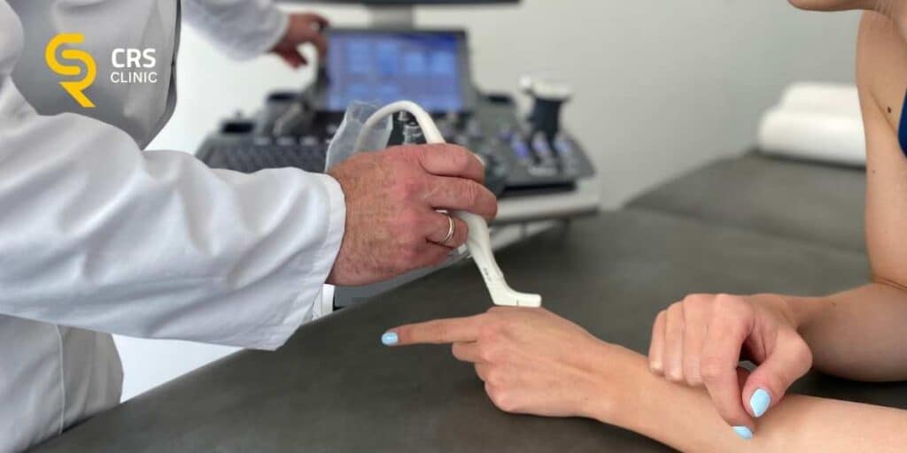 Lekarz ortopeda wykonuje badanie ultrasonograficzne palca zatrzaskującego w CRS Clinic Warszawa