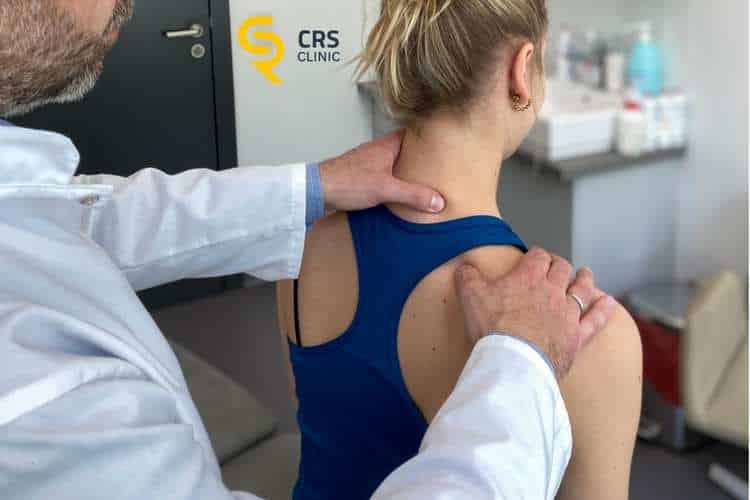 Lekarz ortopeda wykonuje dokładną diagnostykę odcinka szyjnego kręgosłupa u pacjentki w CRS Clinic Warszawa