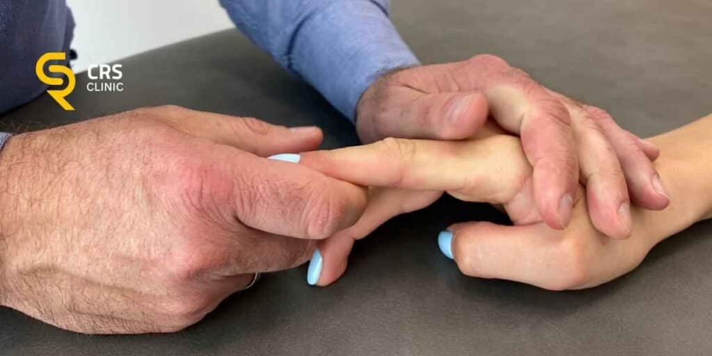 Ortopeda przeprowadza badanie kliniczne palca zatrzaskującego w CRS Clinic Warszawa