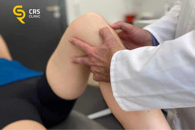 Ortopeda wykonuje dokładne badanie kliniczne kolana przed rozpoczęciem rehabilitacji w CRS Clinic Warszawa