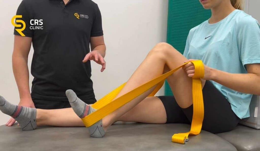 Fizjoterapeuta pracuje z pacjentką i wykonuje ćwiczenia wzmacniające mięśnie na ostrogę piętową w CRS Clinic Warszawa