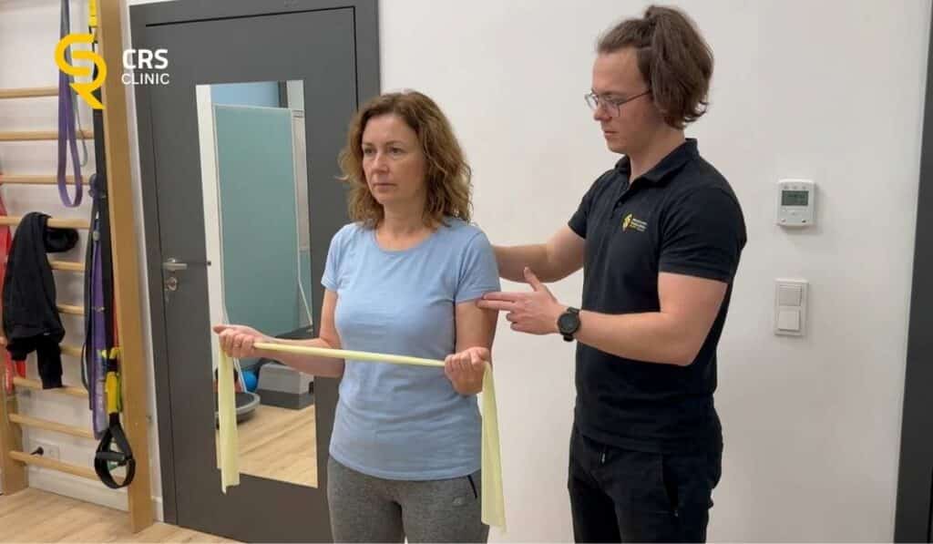 Fizjoterapeuta wykonuje ćwiczenia z pacjentką na wzmocnienie barku przy zamrożonym barku w CRS Clinic Warszawa
