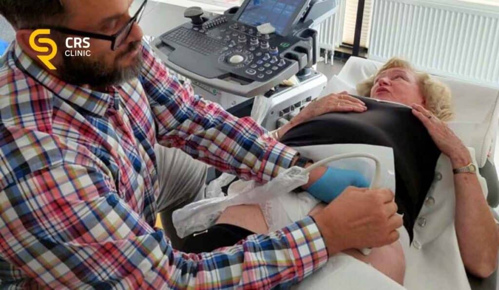 Lekarz ortopeda przeprowadza badanie USG biodra przy zapaleniu kaletki krętarza w CRS Clinic Warszawa