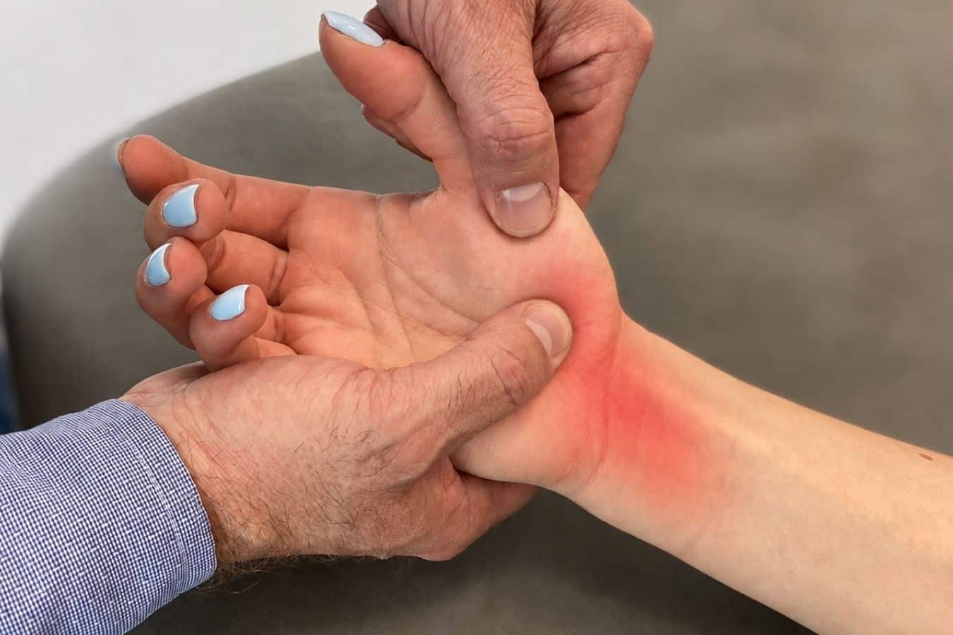 Lekarz ortopeda przeprowadza badanie kliniczne ręki u pacjentki z chorobą de Quervaina w CRS Clinic Warszawa